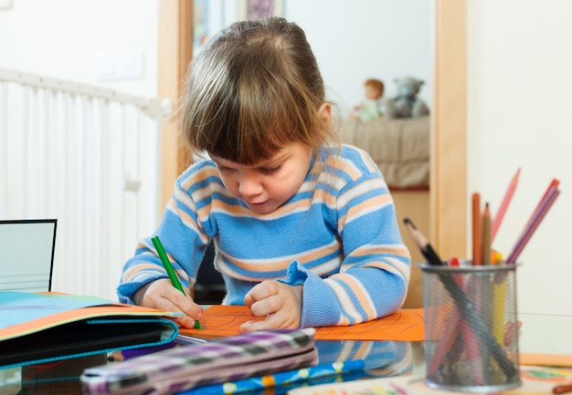 Bambino serio disegno su carta in casa