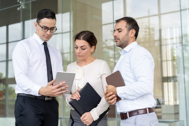 Serious colleagues reading e-mail with business data