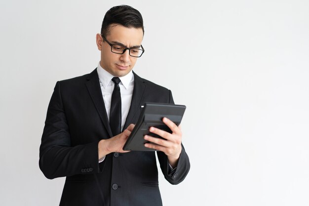 Serious concentrated financial advisor using calculator.