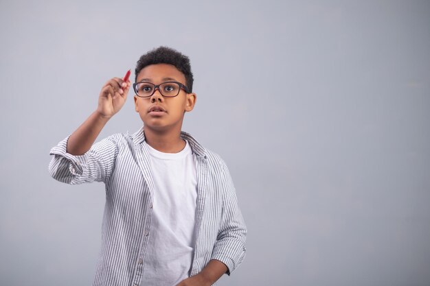 Serious concentrated kid drawing with a pencil