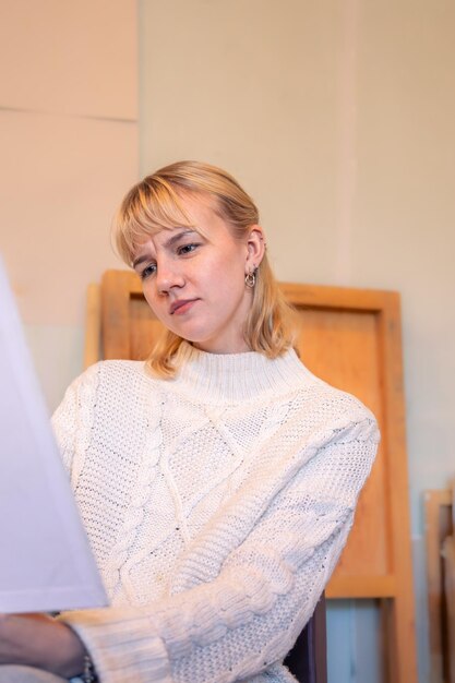 a serious and concentrated woman artist artist painting at easel