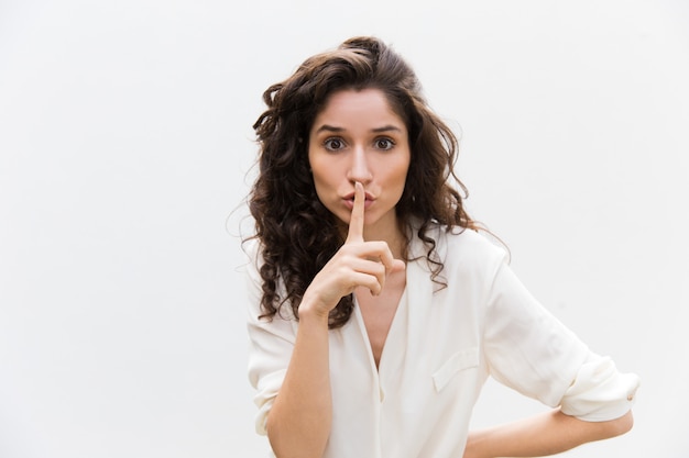 Free photo serious concerned woman showing shh gesture