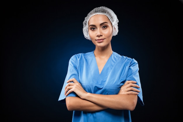 Free photo serious confident doctor looking and holding hands folded