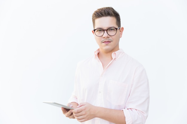 Serious confident software developer posing with tablet