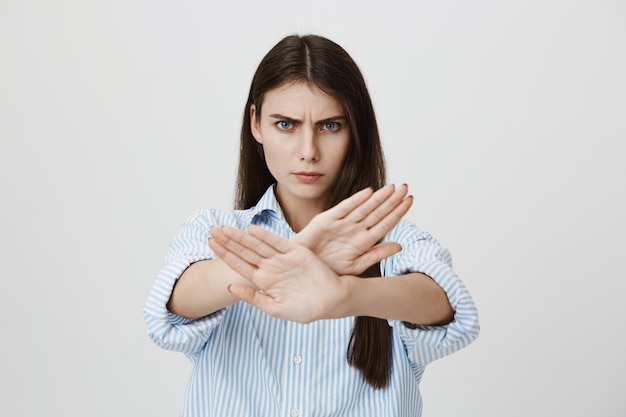 Free photo serious confident woman show stop sign, cross gesture