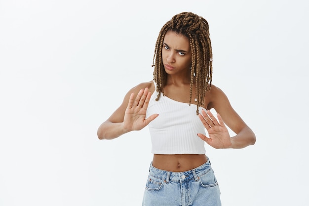 Foto gratuita ragazza afro-americana dispiaciuta seria che mostra il gesto di arresto, proibisce l'azione, rifiuta