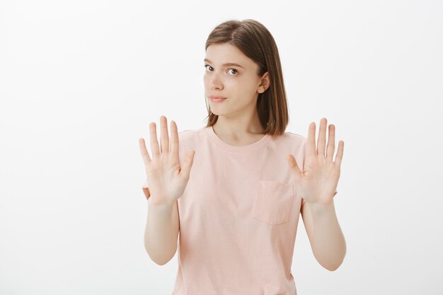 Serious displeased woman don't want something, showing stop or taboo gesture, reject offer