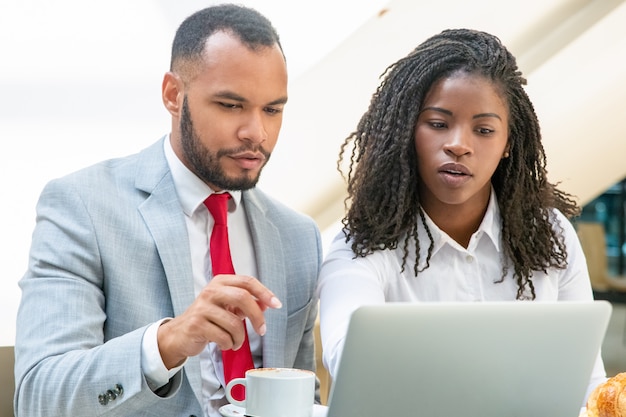 Diversi giovani colleghi seri che lavorano insieme al progetto