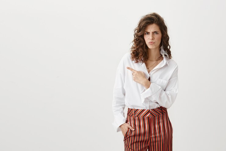 Free Photo serious doubtful attractive woman squinting suspicious and pointing left