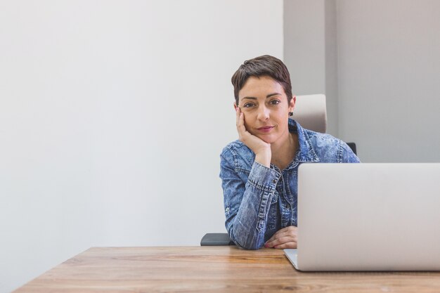 serious employee posing with one hand on her cheek