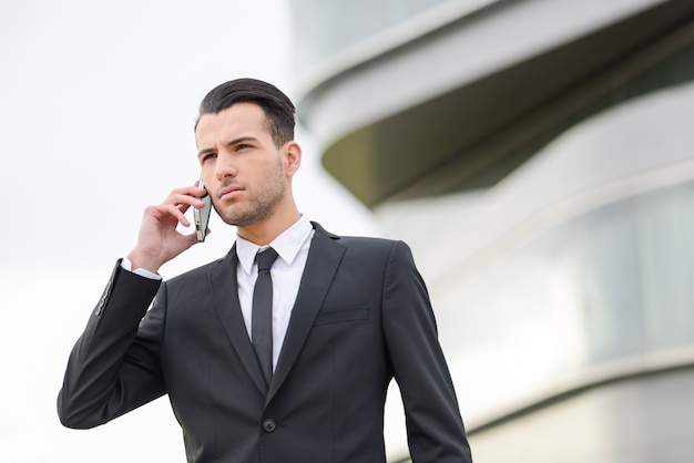 Serious employee using his mobile phone