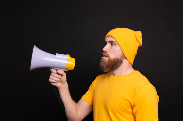 Serious european man with megaphone on black background