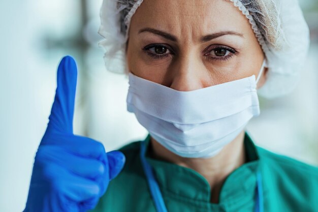Serious female doctor with with her index finger raised looking at camera