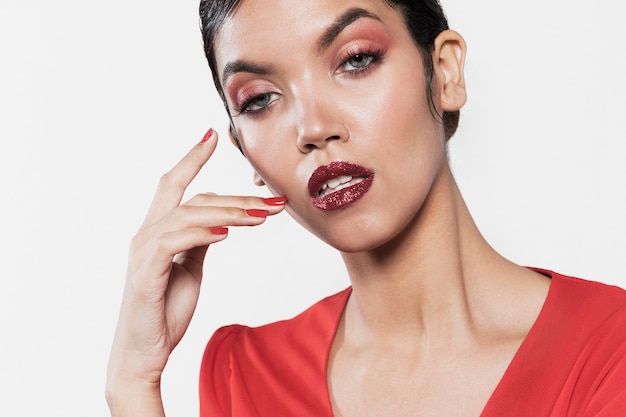 Serious female model wearing vibrant clothes and make-up