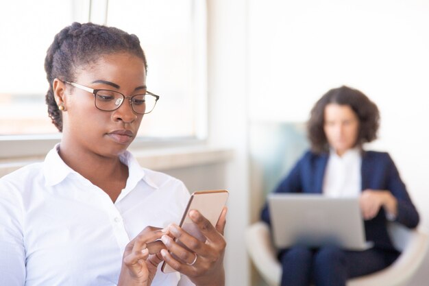 Serious female office worker checking messages