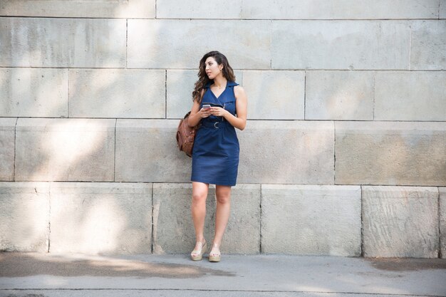 Serious female tourist with bag waiting for taxi