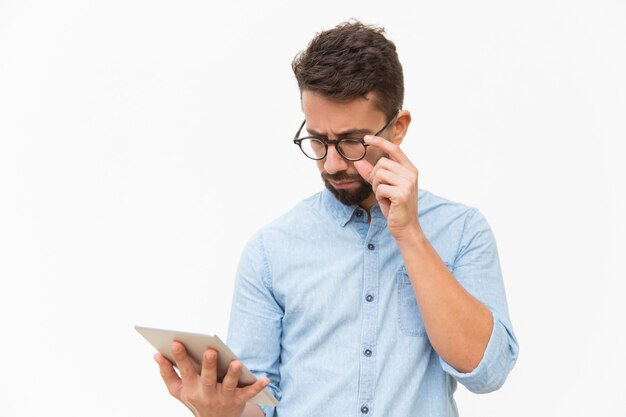 Serious focused guy reading important message