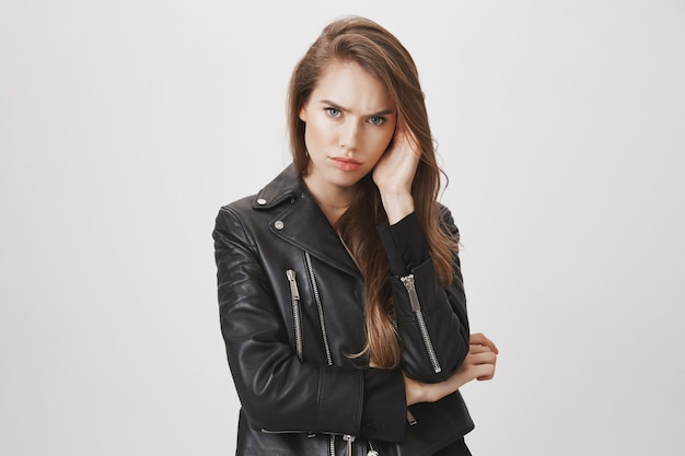 Serious frowning, attractive woman in leather jacket