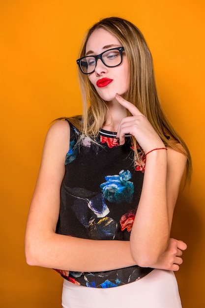 The serious frustrated young beautiful business woman on orange wall