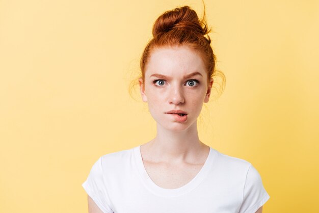 Tシャツの深刻な生姜女性が彼女の唇を噛む