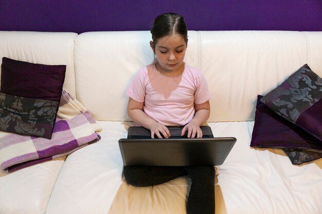 Серьезная девушка, используя ноутбук на диване