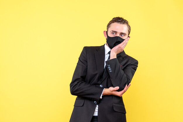 Serious guy in deep thinking while standing on yellow