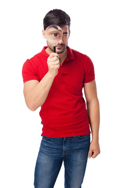 Serious guy playing with a magnifying glass