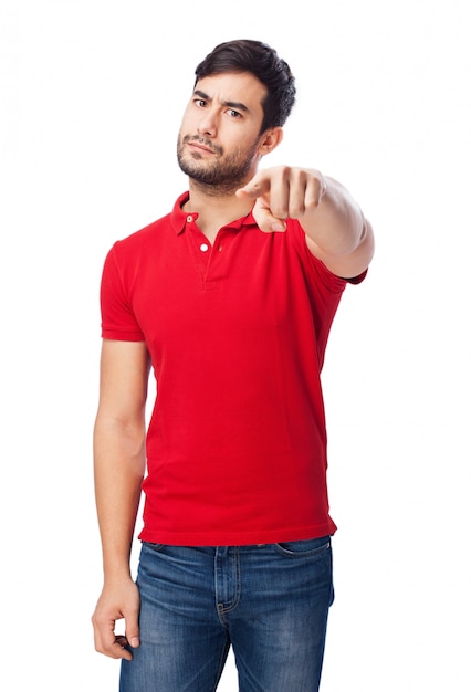 Serious guy with red t-shirt pointing at something