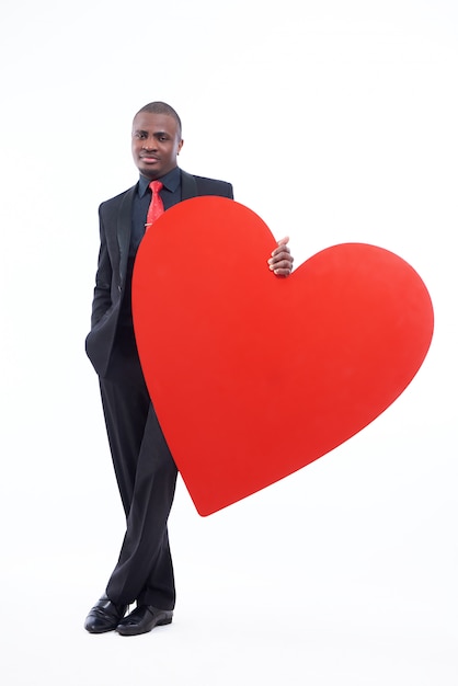 Serious and handsome african man holding big red heart