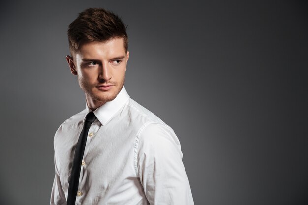 Serious handsome man in shirt and tie standing