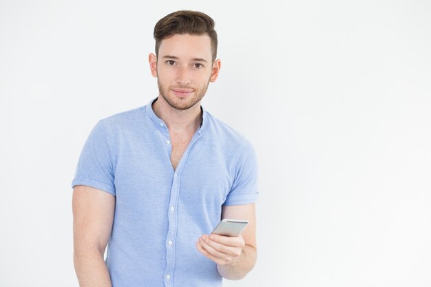 Serious handsome young man using smartphone