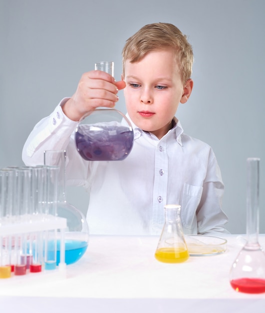 Free photo serious kid holding a flask