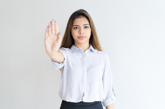 Serious lady showing open palm or stop gesture