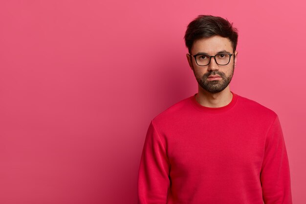 Serious looking bearded man looks with confident expression