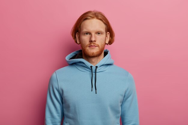 Serious looking confident bearded man with ginger hair