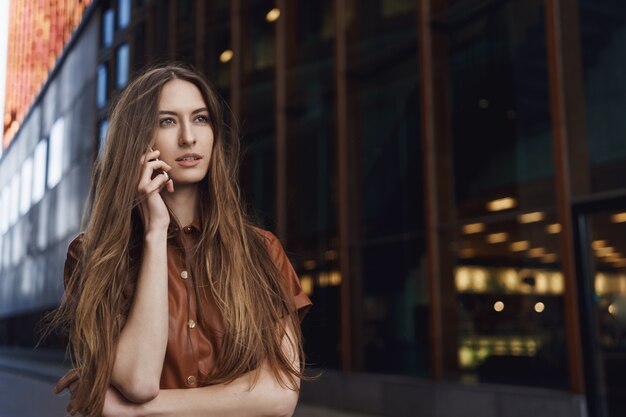 Serious-looking confident gorgeous female speaking on the mobile phone.