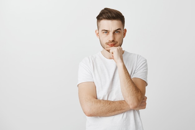 Serious-looking perplexed young man making important decision