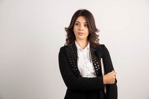 Serious looking teacher in uniform posing on white.