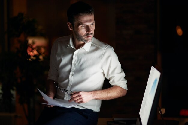 Serious man analyzing document in his office