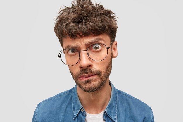 Serious man boss with trendy hairdo looks in bewilderment