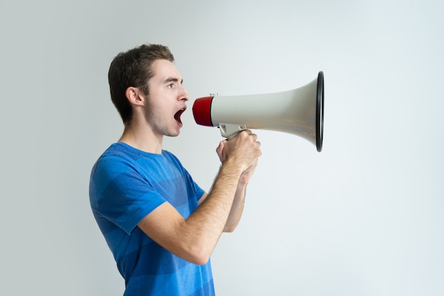 Serious man holding megaphone and screaming into it