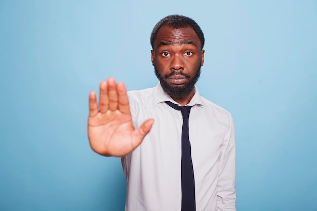 Foto gratuita uomo serio che fa il segno stop con la mano.