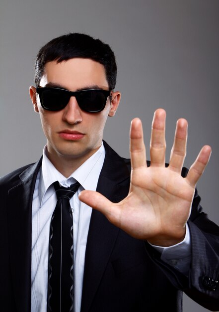 Serious man in suit shows stop sign