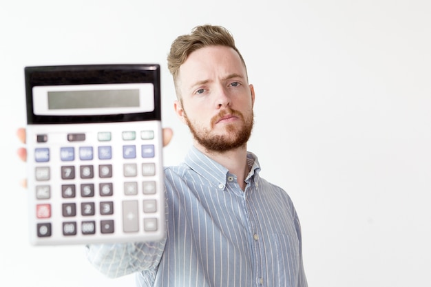 Free photo serious manager stretching hand with calculator