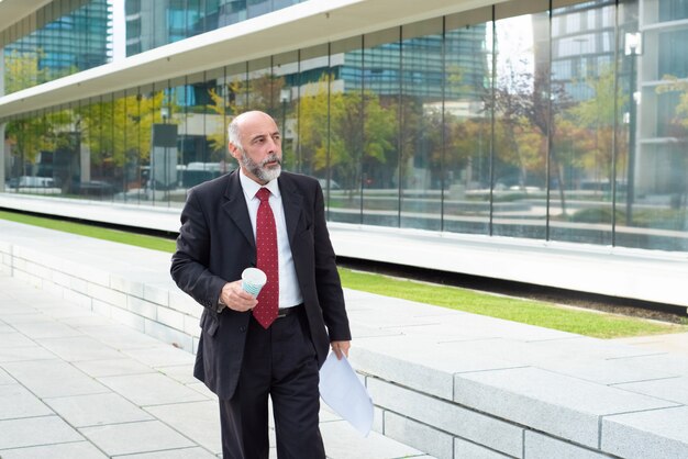 Serious mature company owner drinking coffee