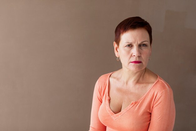 Serious mature woman with plain background