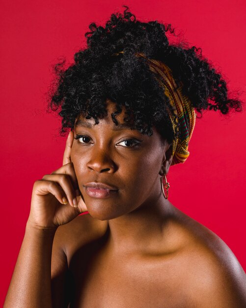 Serious naked ethnic curly young woman on colored background