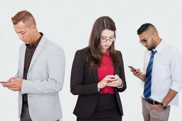 Serious partners using smartphones at meeting