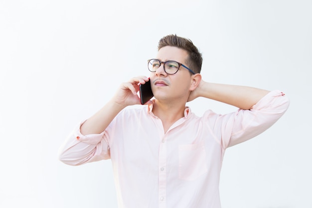 Serious pensive guy in eyeglasses touching head