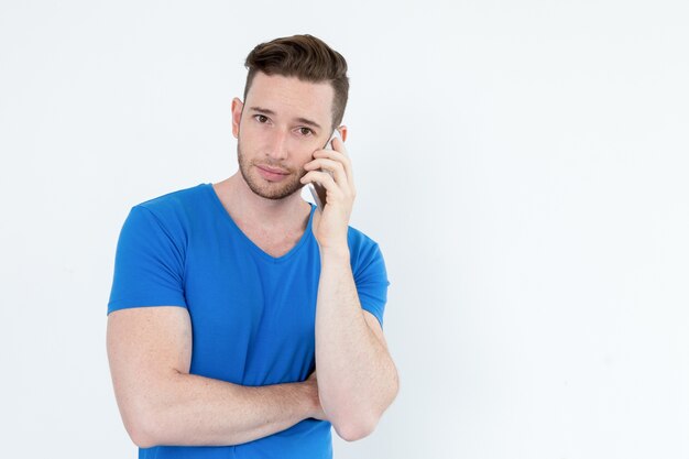 Serious pensive young man talking on phone